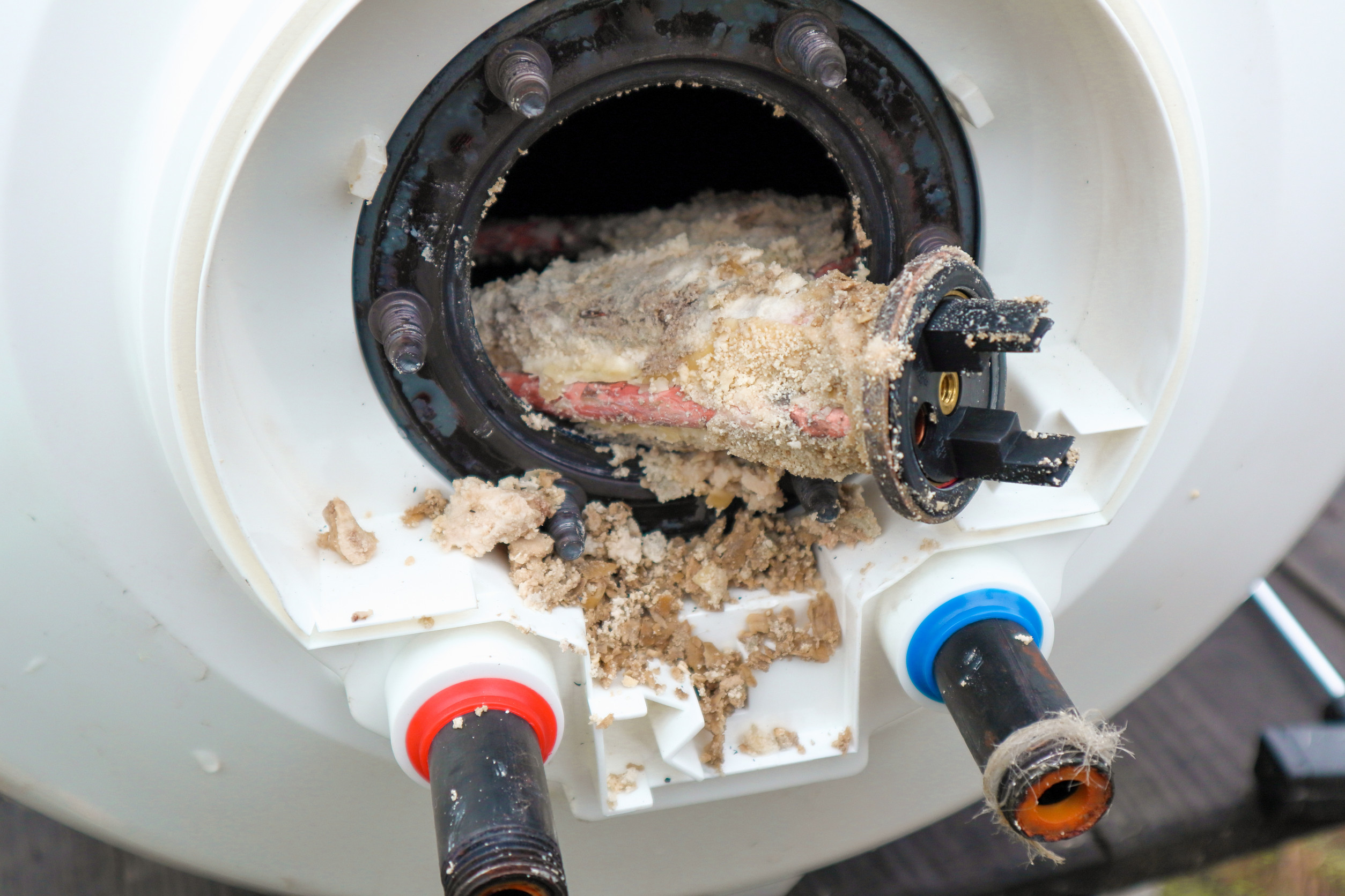 Cross-section diagram of water heater tank showing sediment buildup