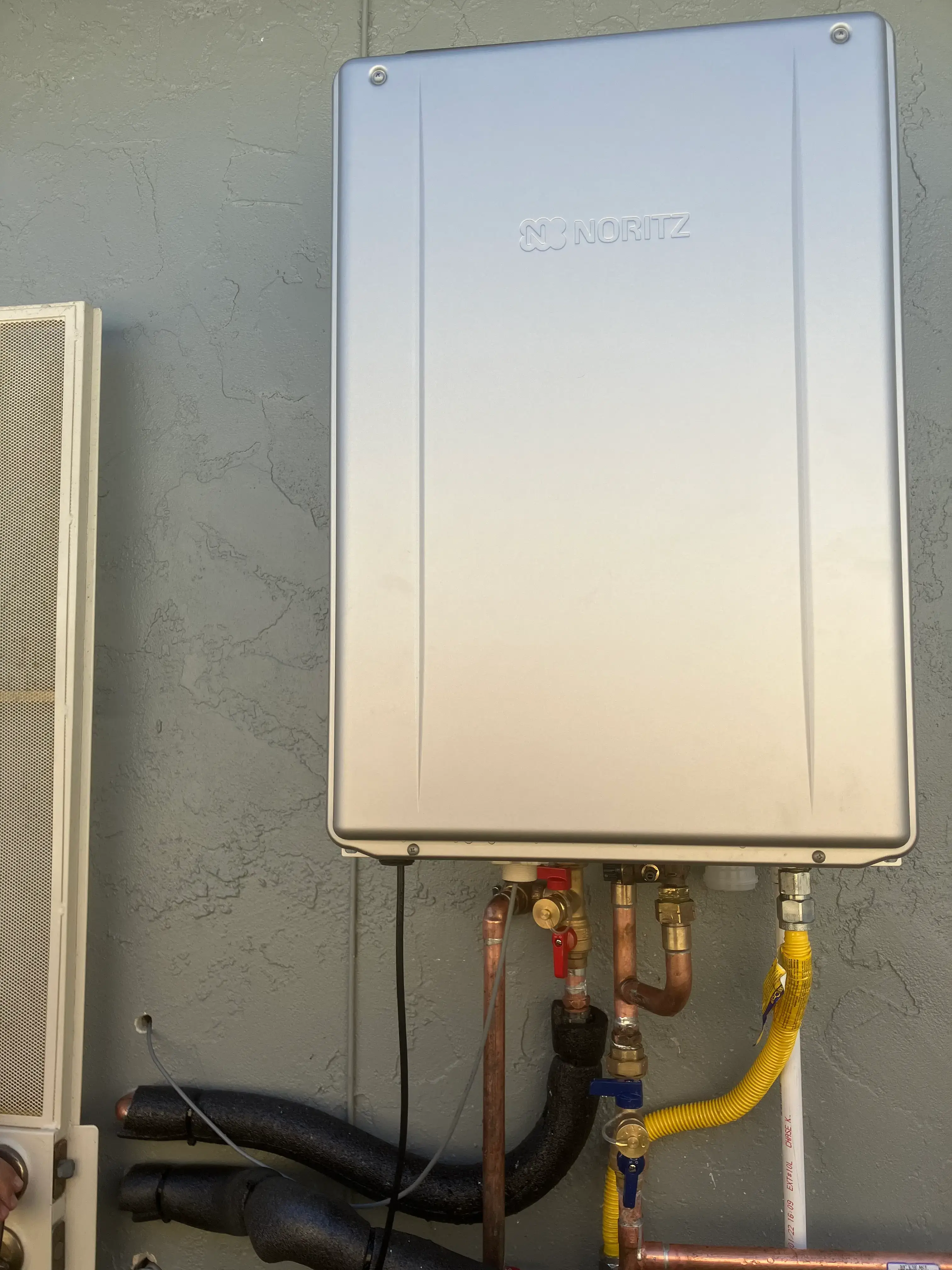 Tankless water heater mounted on exterior wall of San Diego home